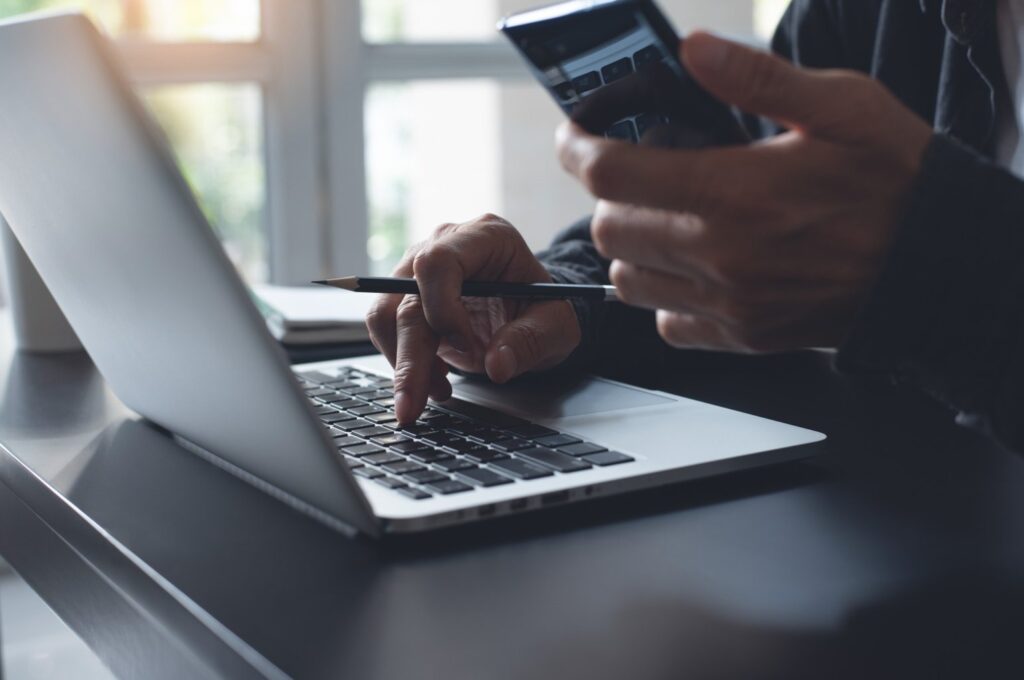 Trabajador en modalidad teletrabajo con su notebook y su celular